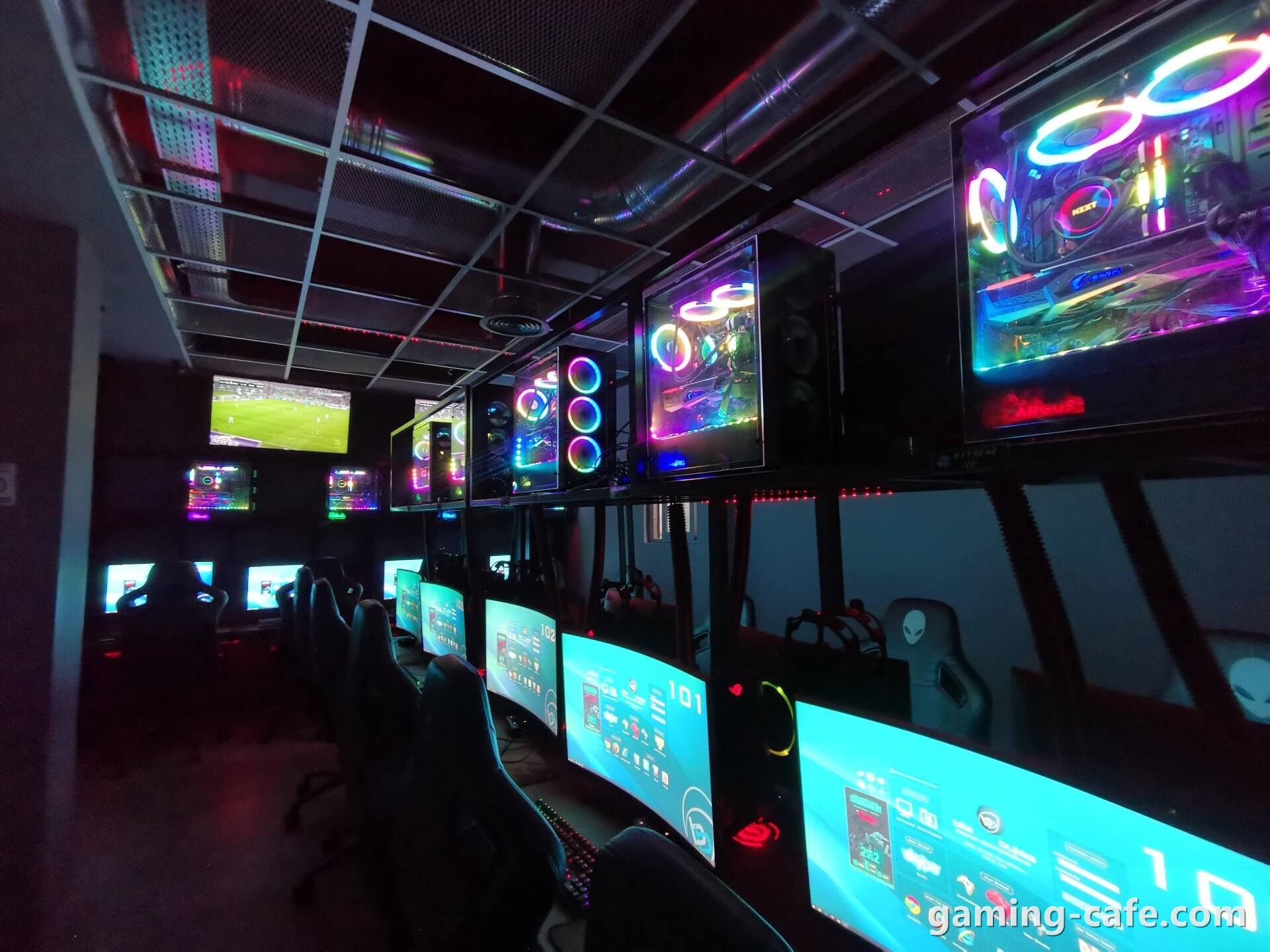 RGB gaming PCs and monitors in a dark gaming cafe