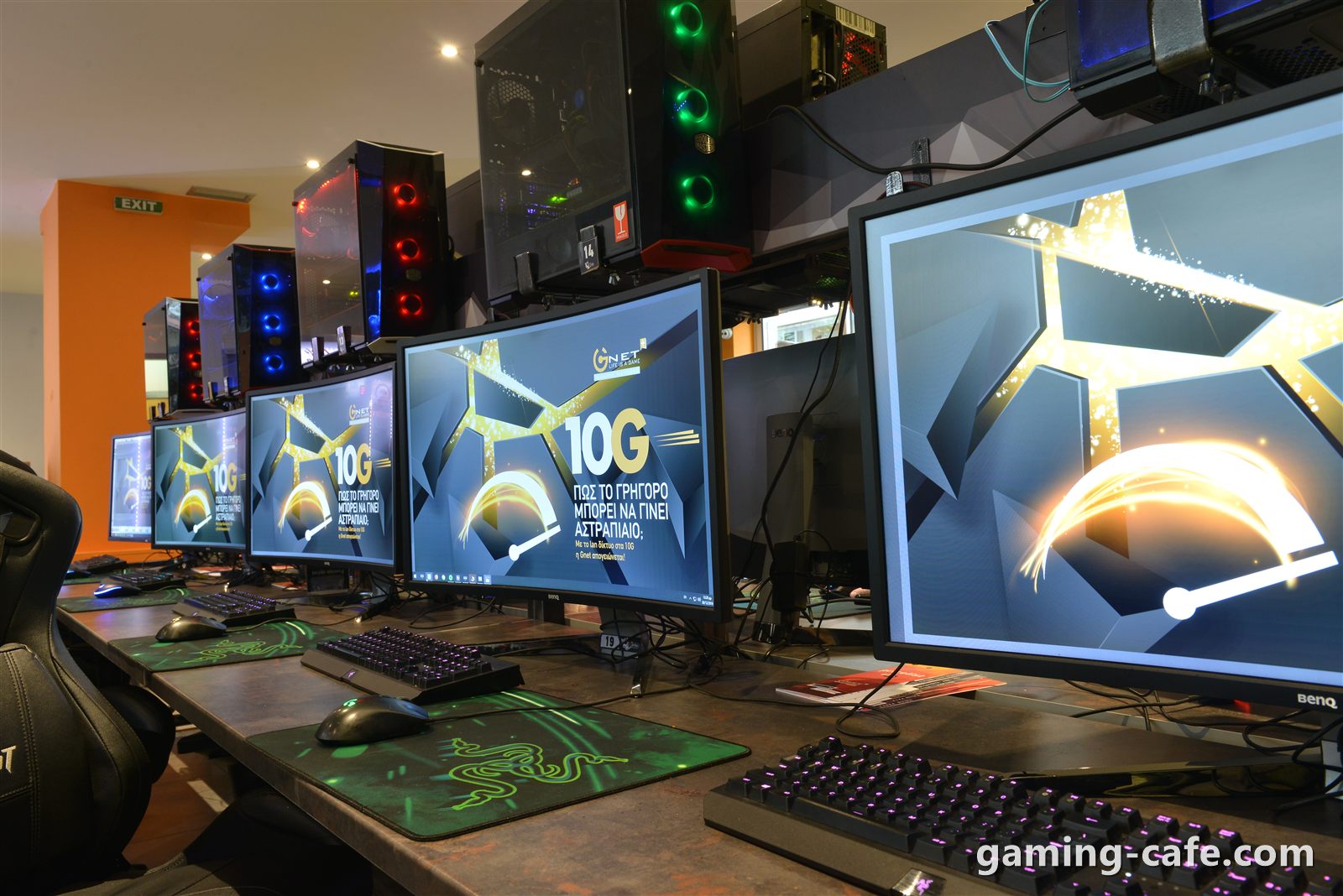 Row of gaming monitors and RGB PCs in an internet cafe